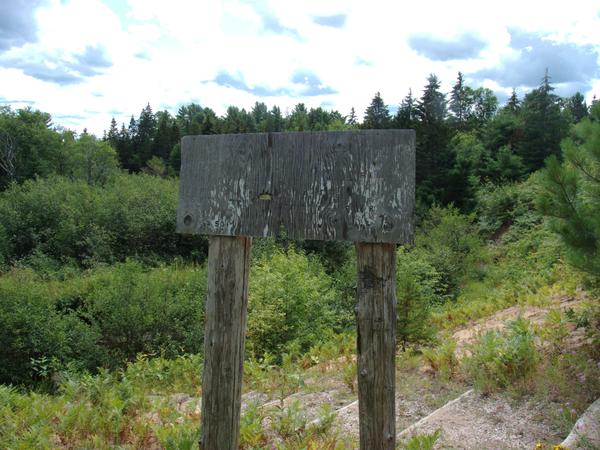 Unreadable sign next to the stairs leading to the Sucker river off Whitewash road.