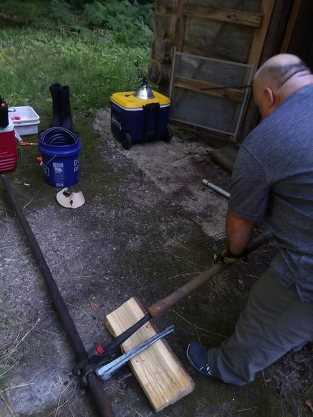 Jon using physics to disconnect two segments of the old well pipe.