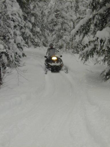 Matt riding into the cabin on the snowmobile he rented.