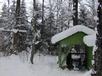 Our snowmobile parked near the wood pile.