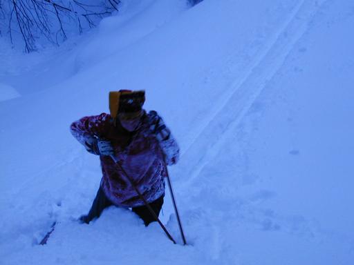 Amelia getting back up after skiing down a steep hill.