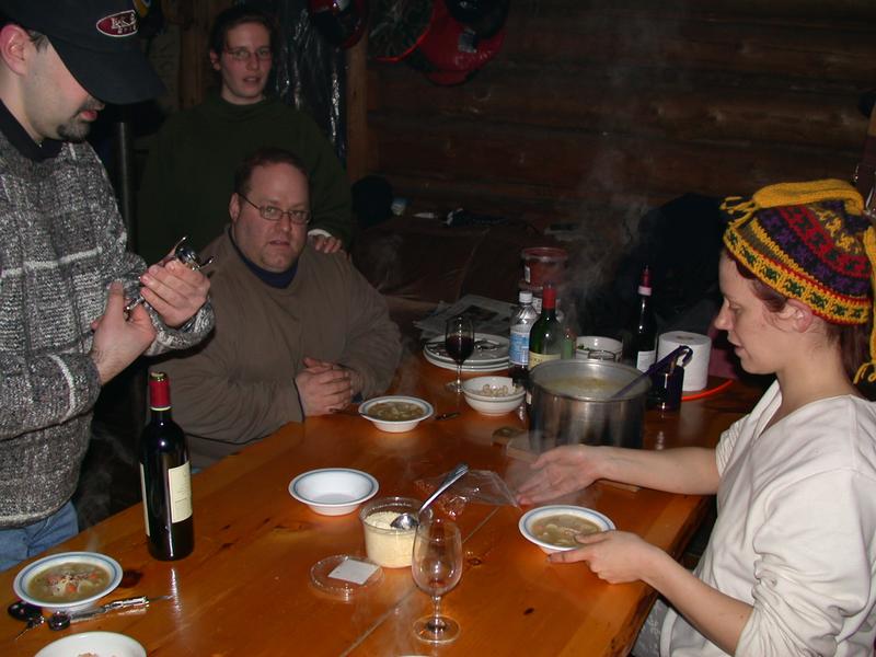 Matt opening some wine while Jon, Amelia, and Vittoria get ready for dinner.