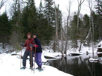 Vittoria and Amelia snowshoeing by a river behind the cabin.