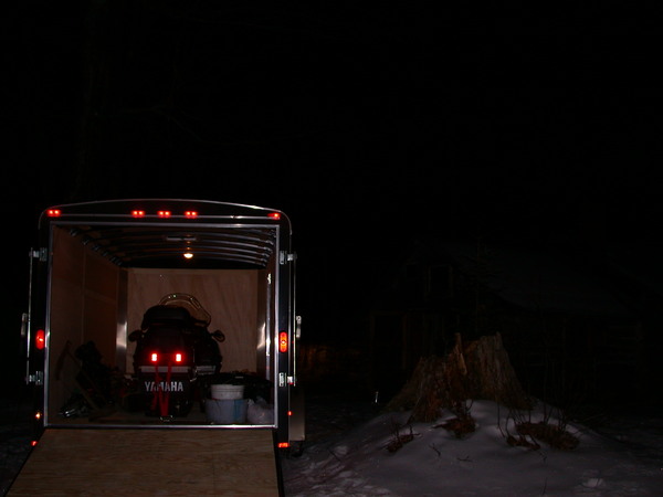 Trailer with snowmobile inside at the cabin.