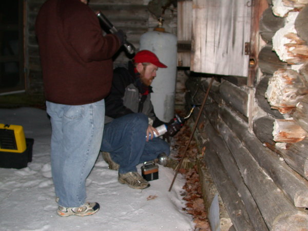 Bill and Jon using a blowtorch to clear water from the
		  gas line.