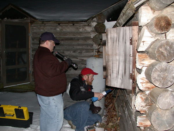 Bill and Jon using a blowtorch to clear water from the
		  gas line.