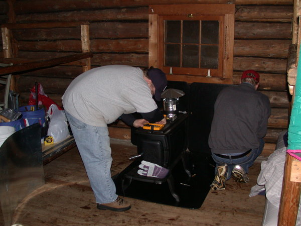 Bill and Jon installing the new wood stove.