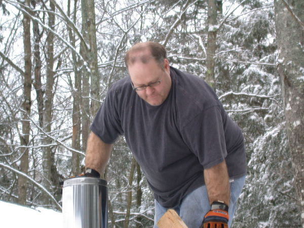 Jon installing the chimney for the new stove.