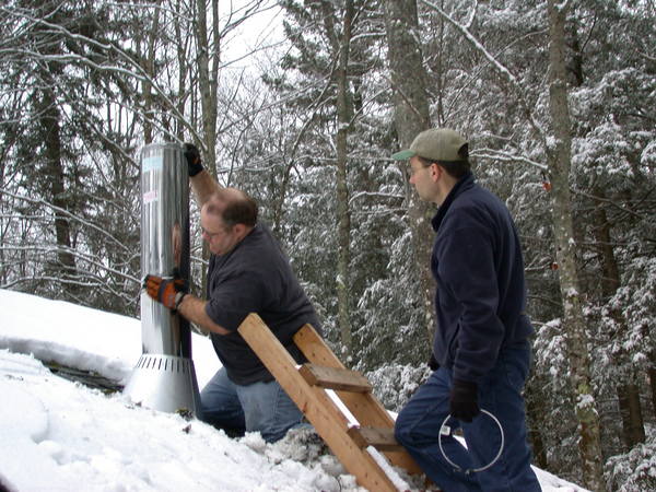 Jon and I installing the chimney for the new stove.