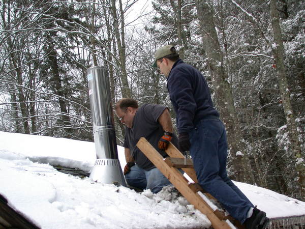 Jon and I installing the chimney for the new stove.