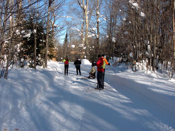 Bill changing the wax on his skis along snowmobile trail 443.