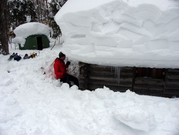 Ed clearing snow from around the Cabin walls.