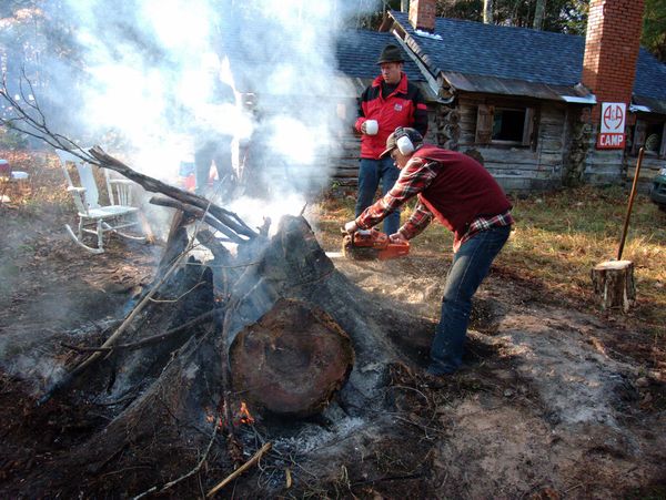 Bill watching Doug chainsaw the stump.