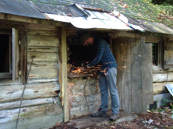 Andy using the angle grinder cutting out part of the old fireplace.