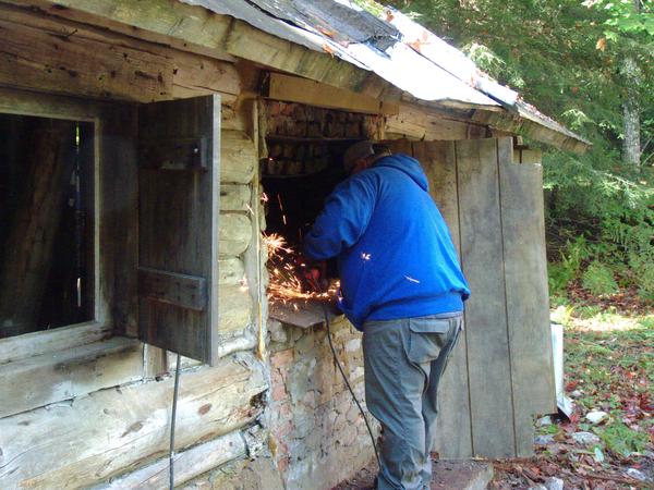 Jon using the angle grinder cutting out part of the old fireplace.