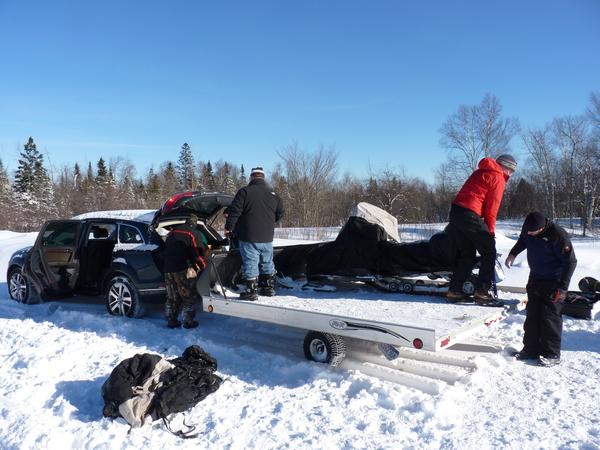 Loading the snowmobiles onto the trailer.