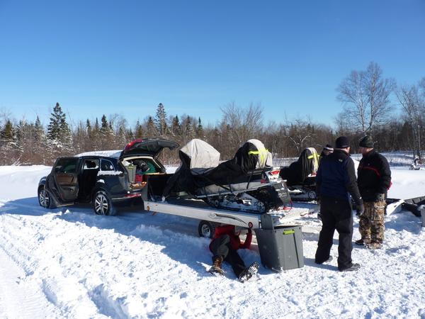 The snowmobiles loaded onto the trailer.