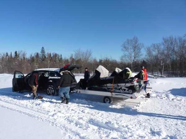 Snowmobiles loaded and secured to the trailer.