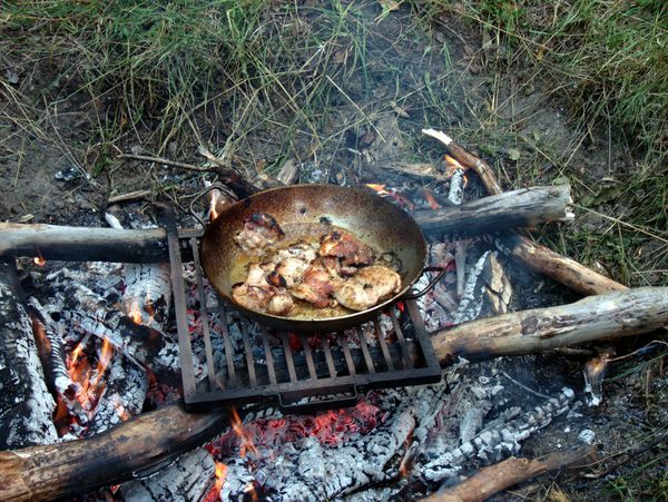 Chicken for the paella cooking on the fire.