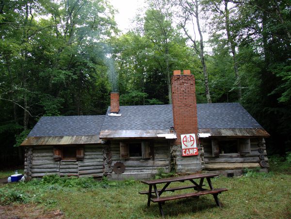 Cabin with the wood stove going (note smoke in smaller
		  chimney).